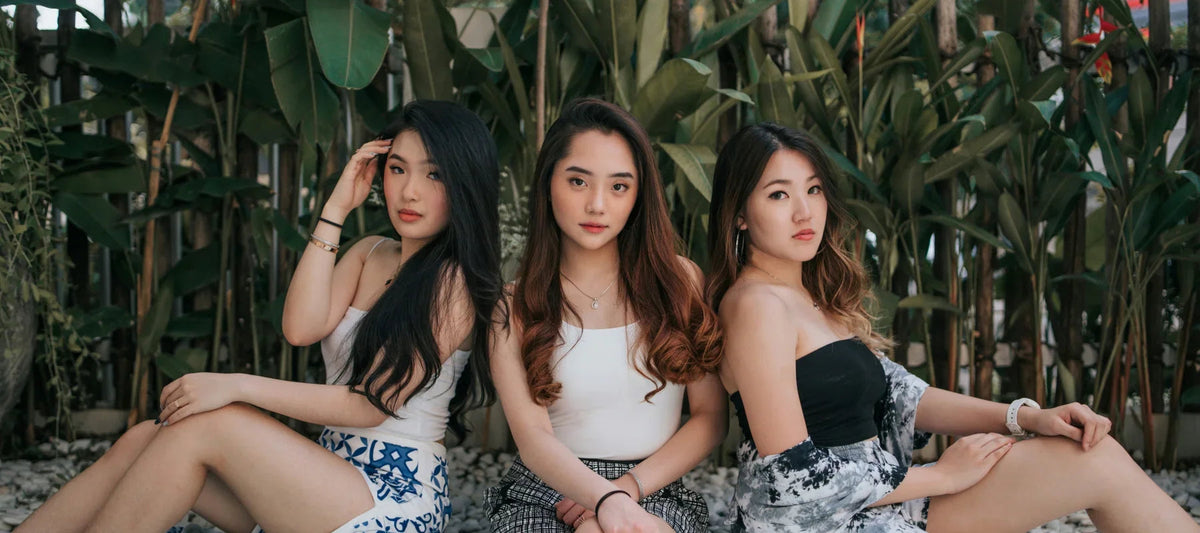 Trois femmes portant des camisoles tendance assises à l’extérieur, ambiance estivale et mode féminine.