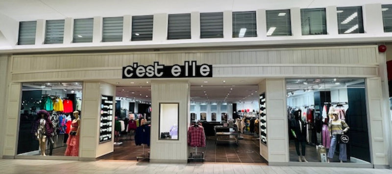 Façade de boutique de vêtements pour femmes avec mannequins et tenues colorées en vitrine