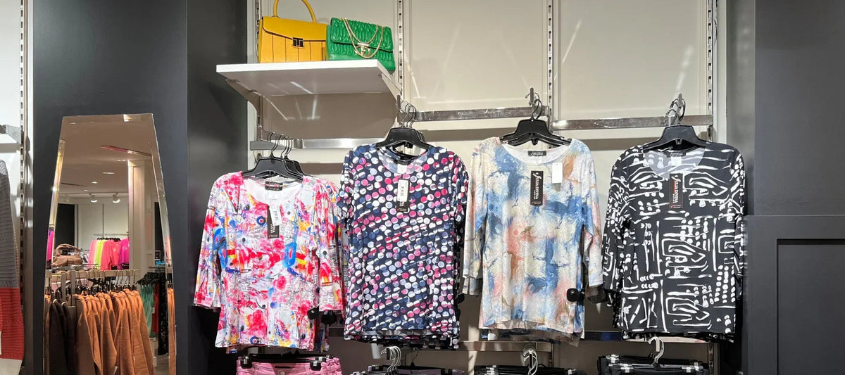 Tops femme à motifs colorés exposés en magasin, sacs à main tendance en arrière-plan