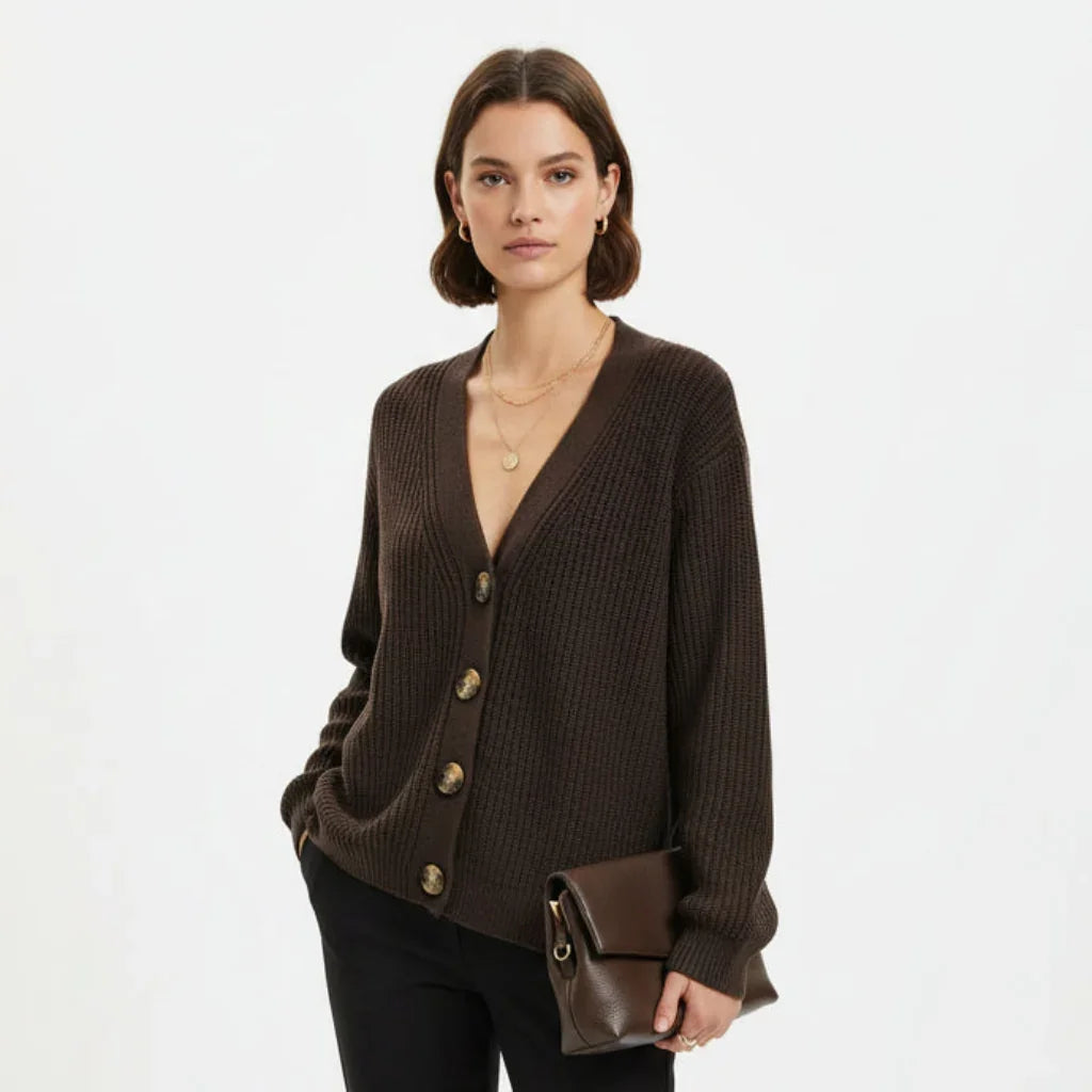 Femme portant un cardigan marron côtelé à boutons et tenant une pochette en cuir marron.