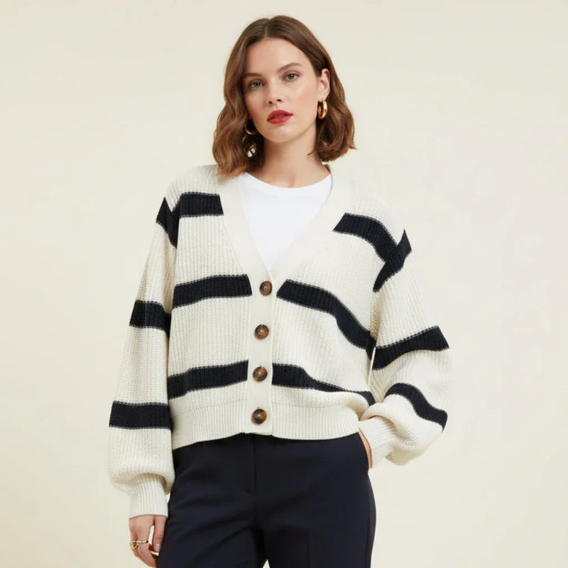 Femme portant un cardigan à rayures horizontales blanc et bleu marine sur un t-shirt blanc.