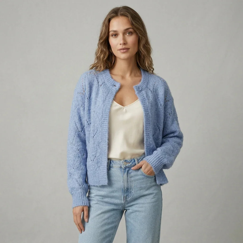 Femme portant un cardigan ajouré bleu C'est Elle avec un top blanc et un jean bleu clair.