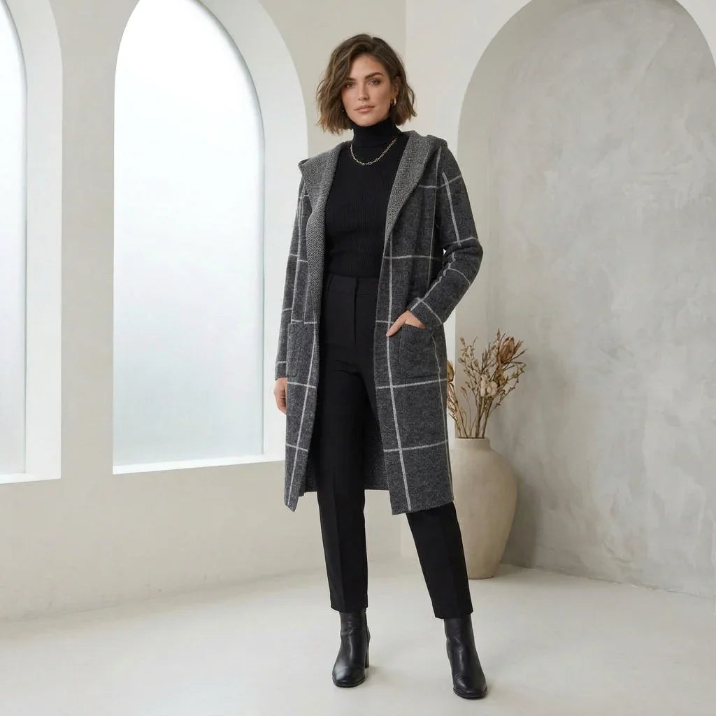 Femme portant un cardigan avec capuchon gris à carreaux, col roulé et pantalon noir C'est Elle.