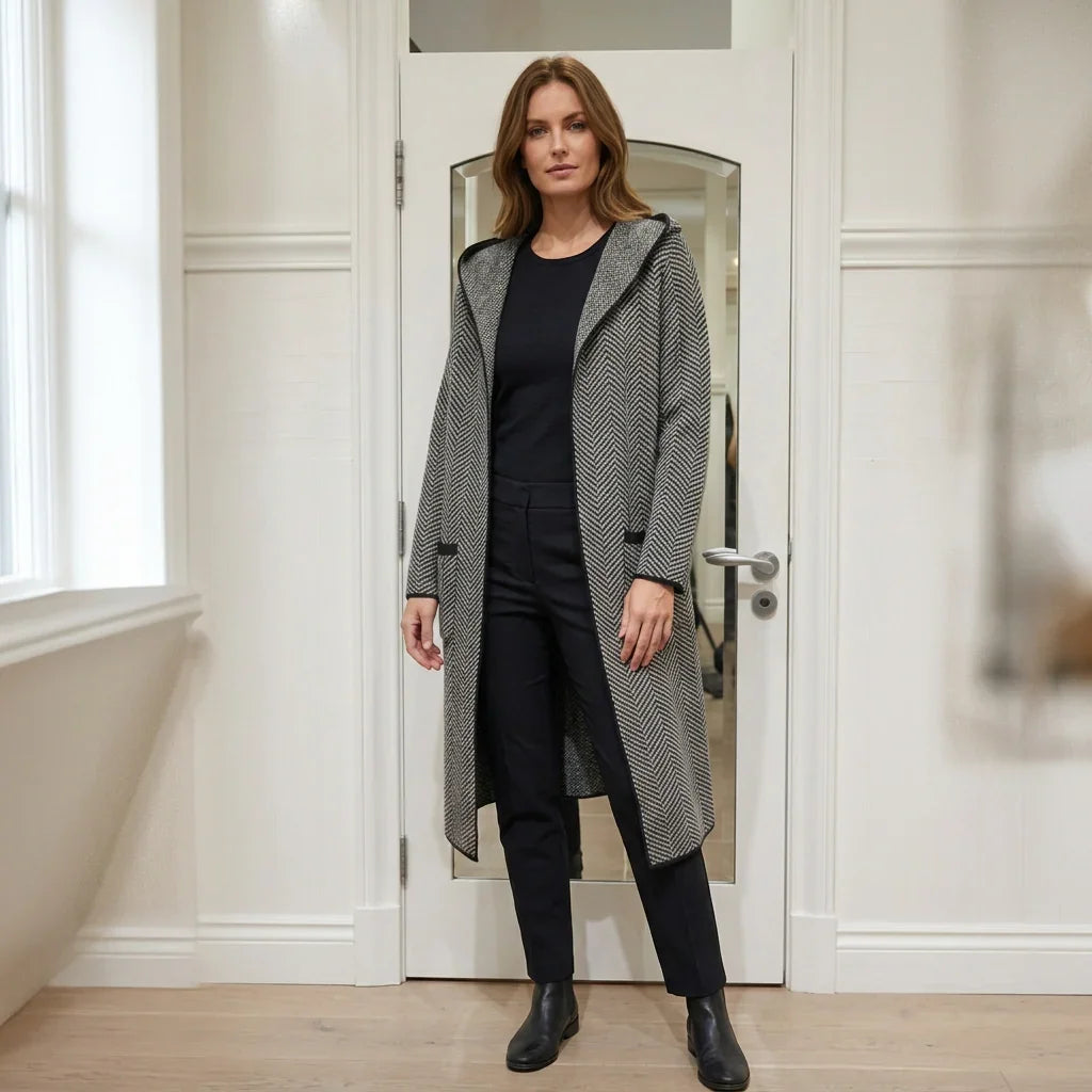 Femme portant un cardigan long à capuchon motif chevrons gris et noir de C'est Elle.