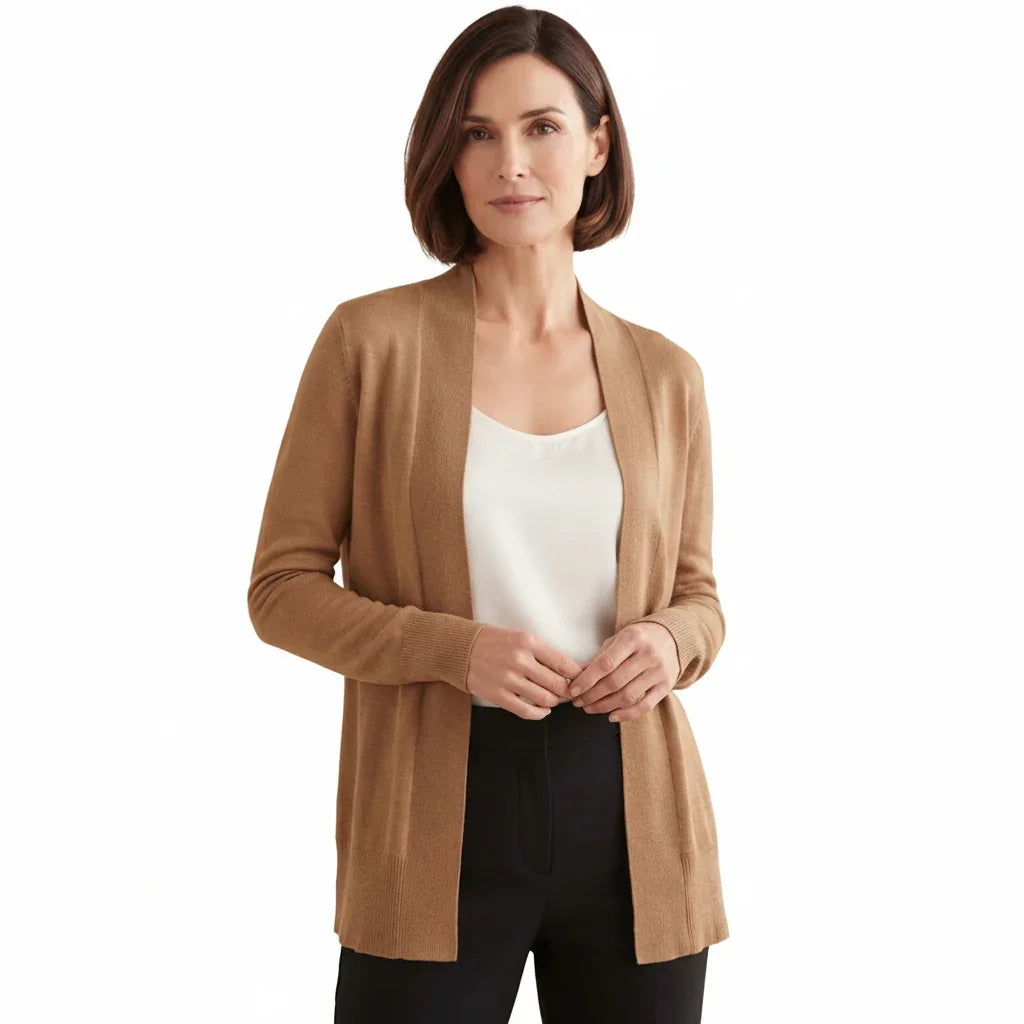 Femme portant un cardigan simple beige C'est Elle sur un haut blanc et un pantalon noir.
