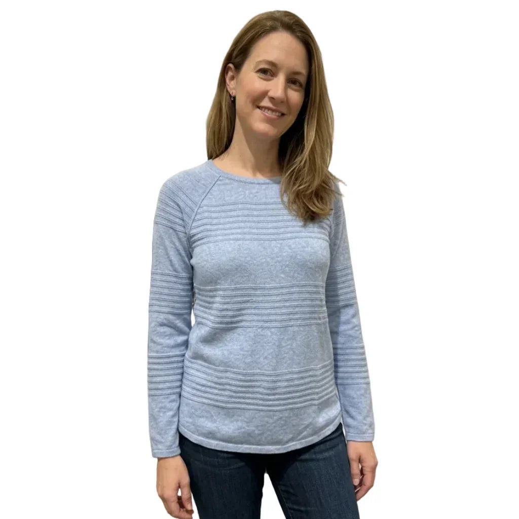 Femme portant un chandail bleu clair à manches longues avec détails texturés