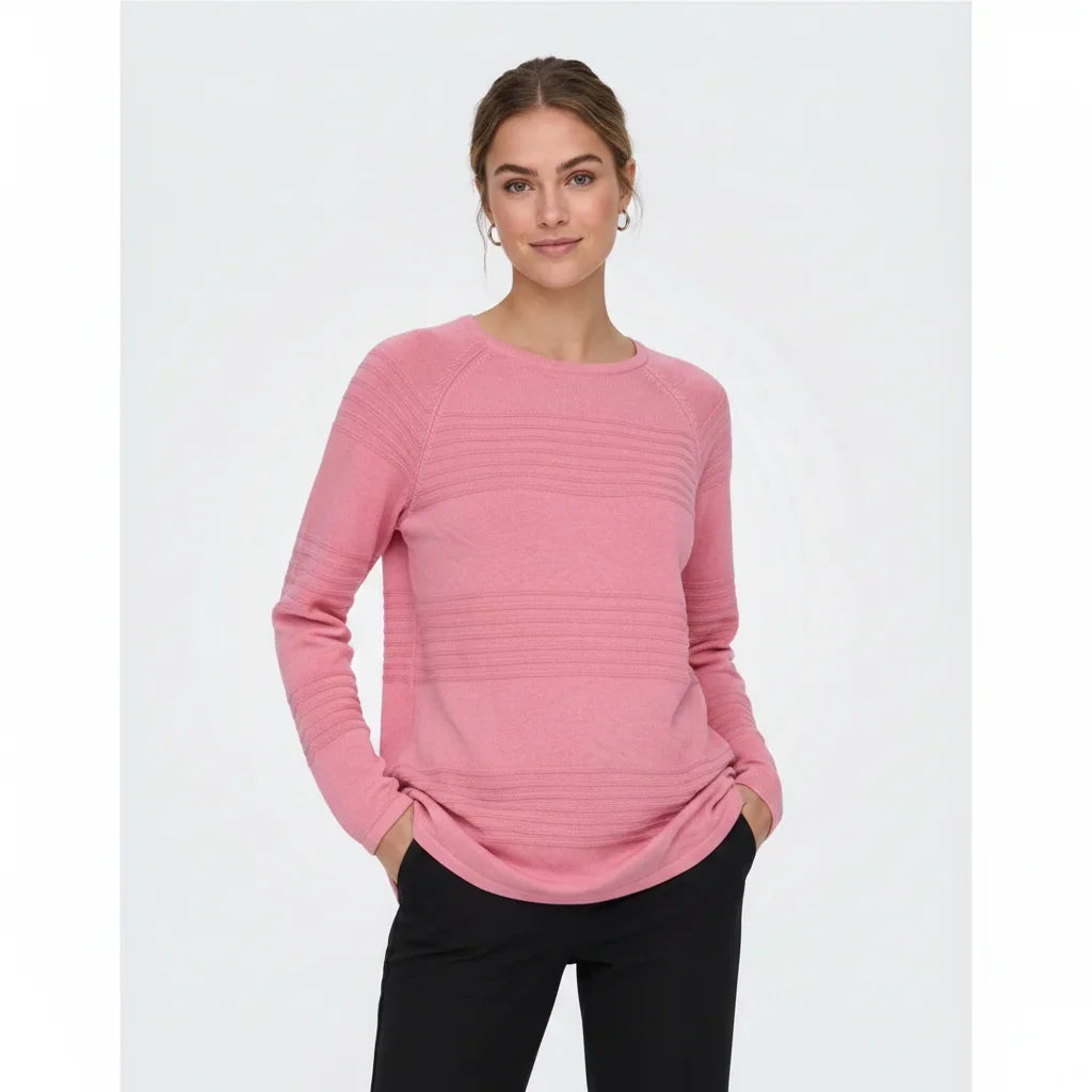 Femme portant un pull rose à manches longues avec détails texturés et pantalon noir.