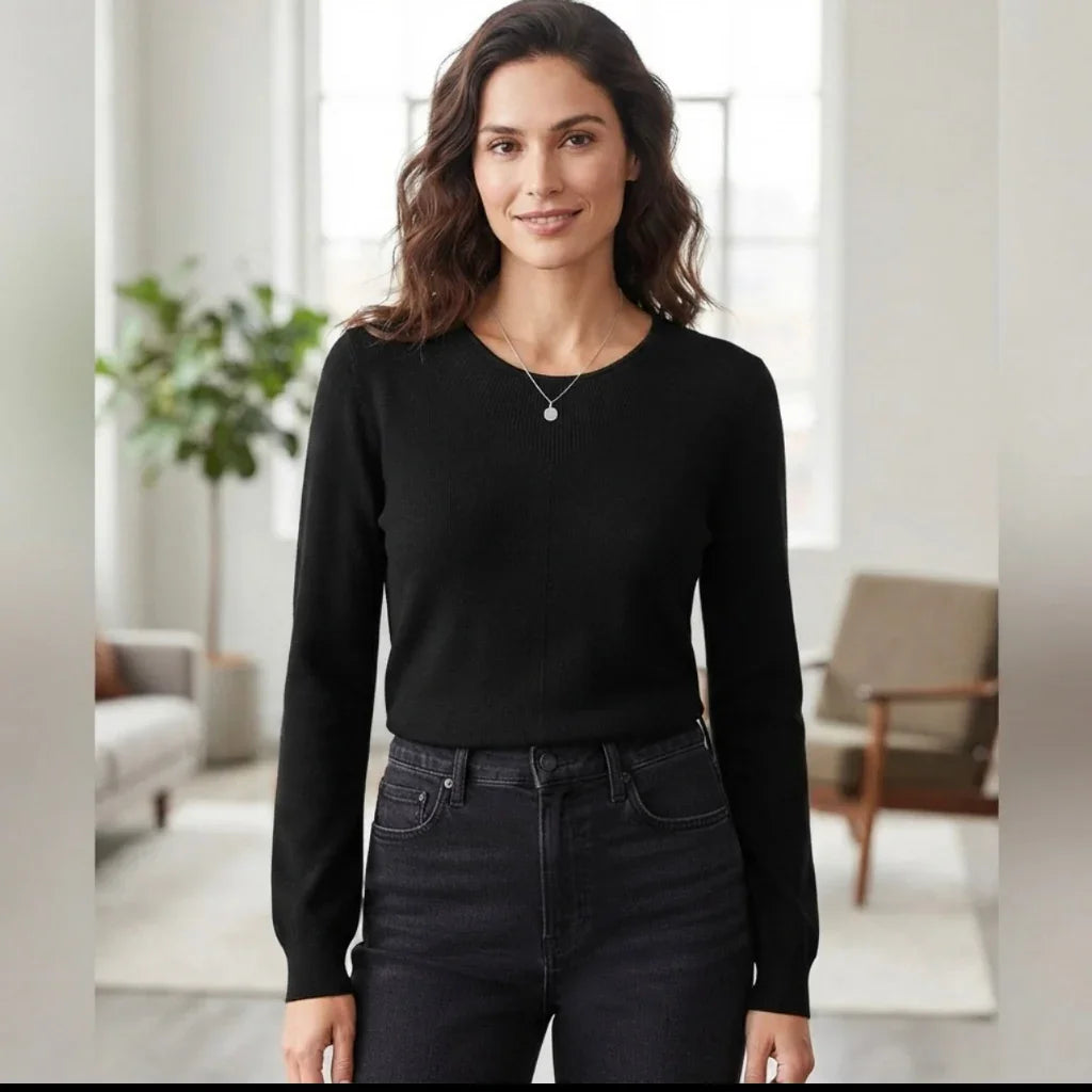 Femme portant un chandail acrylique noir à manches longues et un jean noir de C'est Elle.