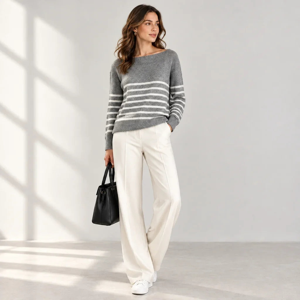 Femme portant un chandail col bateau gris à rayures Only et un pantalon blanc.