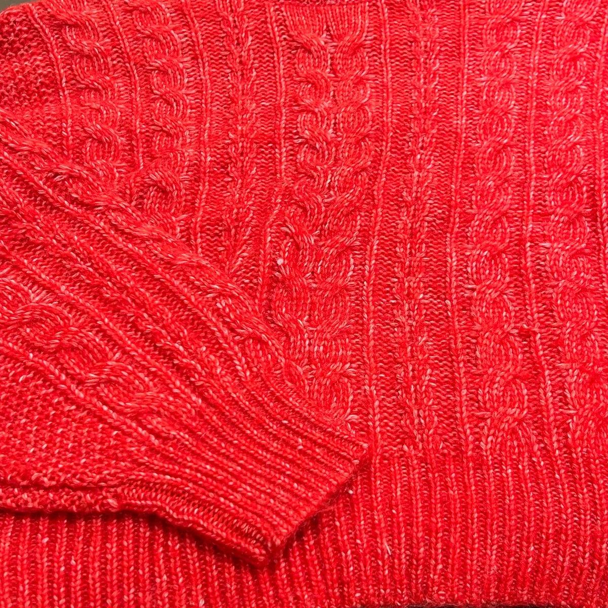 Gros plan d'un pull en maille torsadée rouge vif pour femme