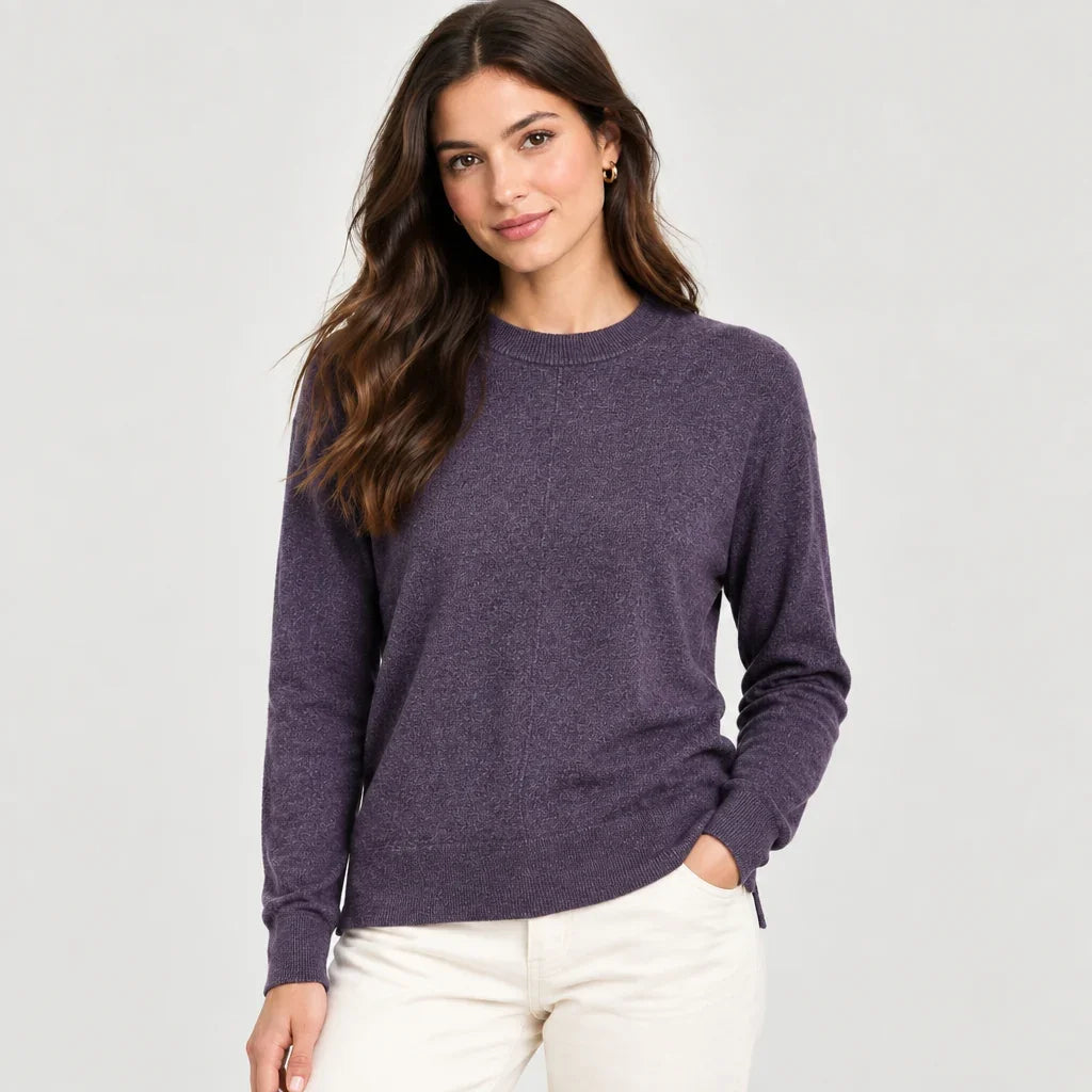 Femme portant un chandail essentials mauve chiné C'est Elle et un pantalon blanc.