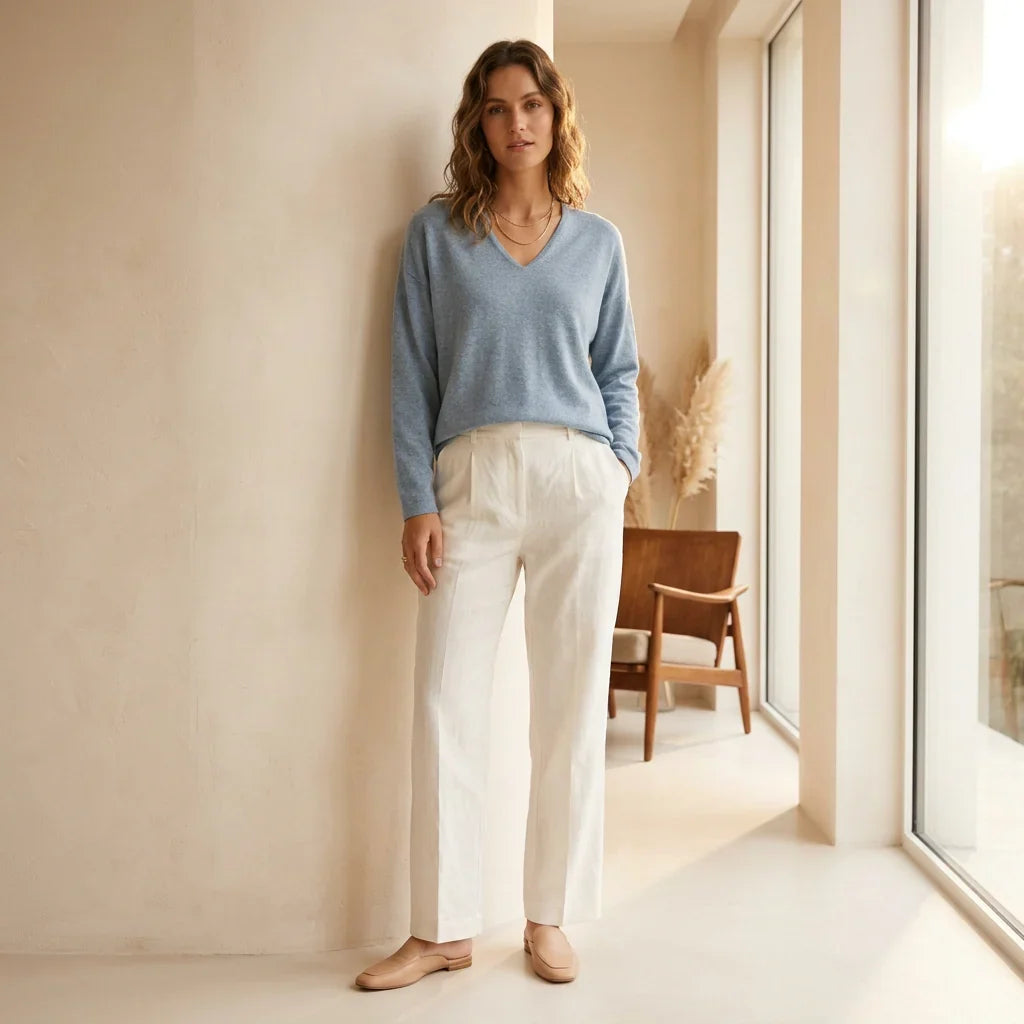 Femme portant un chandail en maille douce bleu C'est Elle et un pantalon blanc.