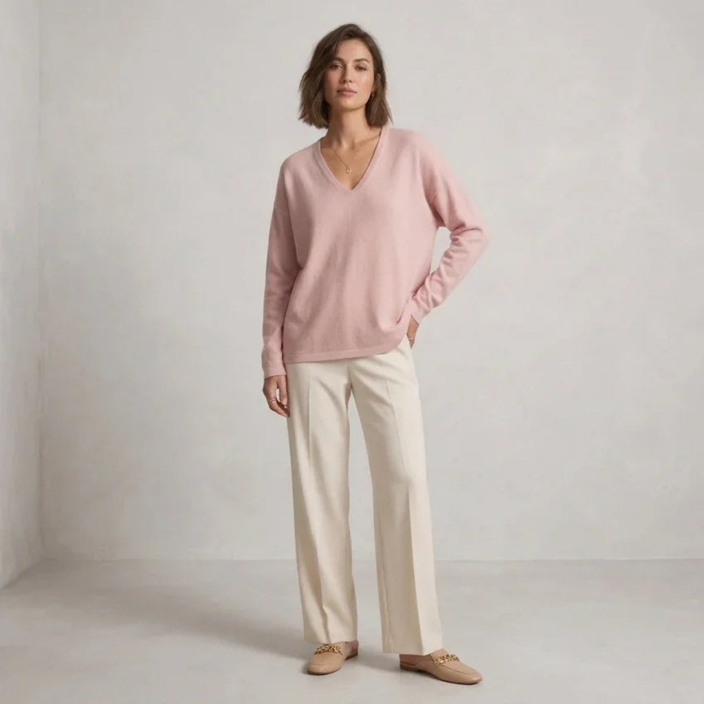 Femme portant un chandail en maille douce rose C'est Elle et un pantalon beige large.