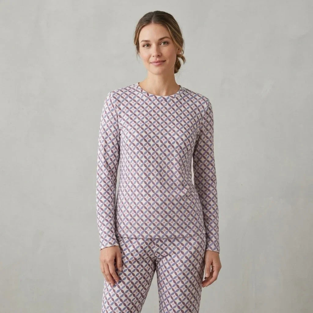 Femme portant un ensemble pyjama assorti à motifs géométriques violets et blancs.