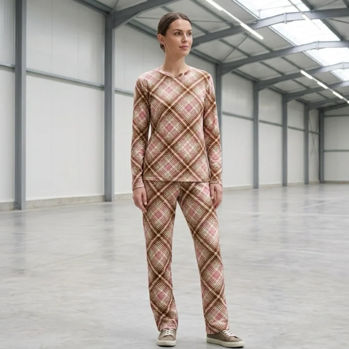 Femme portant un ensemble pyjama à carreaux beiges et roses dans un entrepôt moderne.