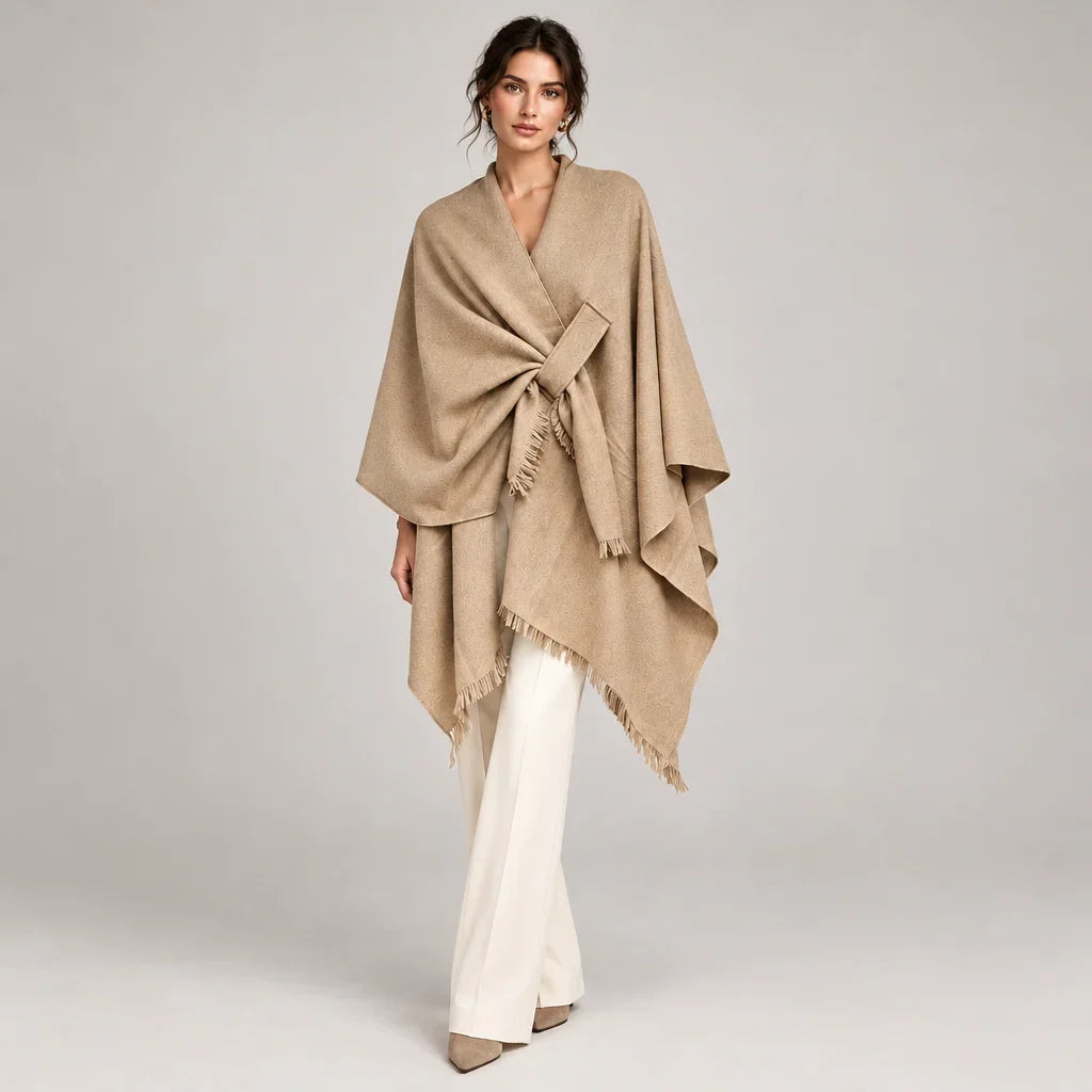 Femme portant un poncho foulard beige noué à la taille avec un pantalon blanc C'est Elle