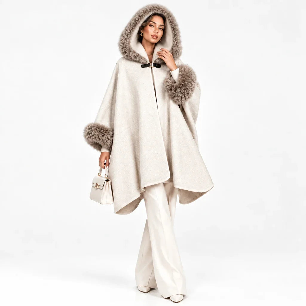 Femme portant un poncho beige à capuche et bordures en fourrure de la marque C'est Elle.