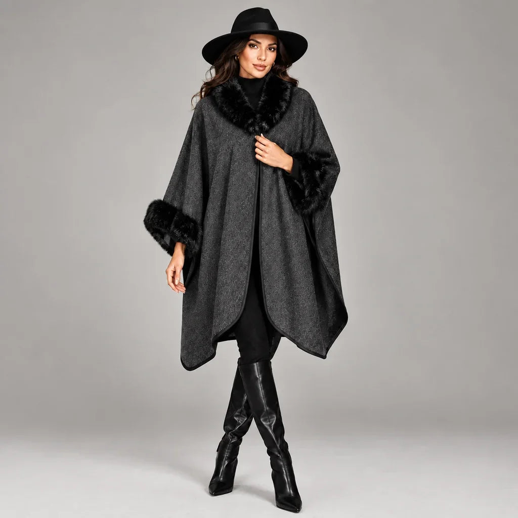 Femme portant un poncho gris avec bordures en fourrure noire et chapeau noir de C'est Elle