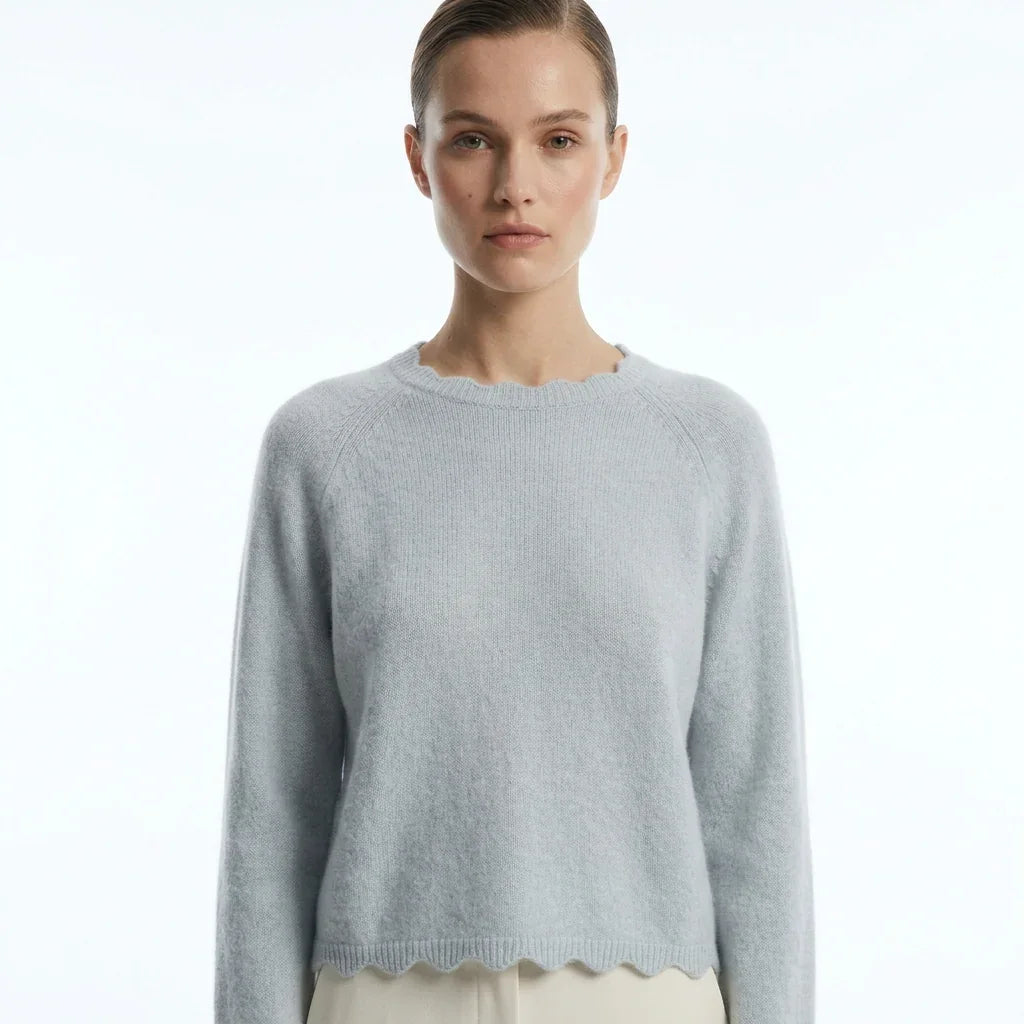 Femme portant un pull col festonné bleu clair de la marque C'est Elle.