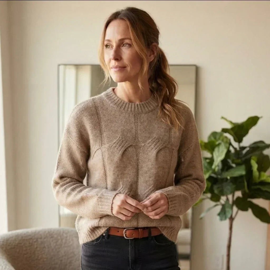 Femme portant un pull col rond texturé beige de la marque Pieces avec un jean noir.