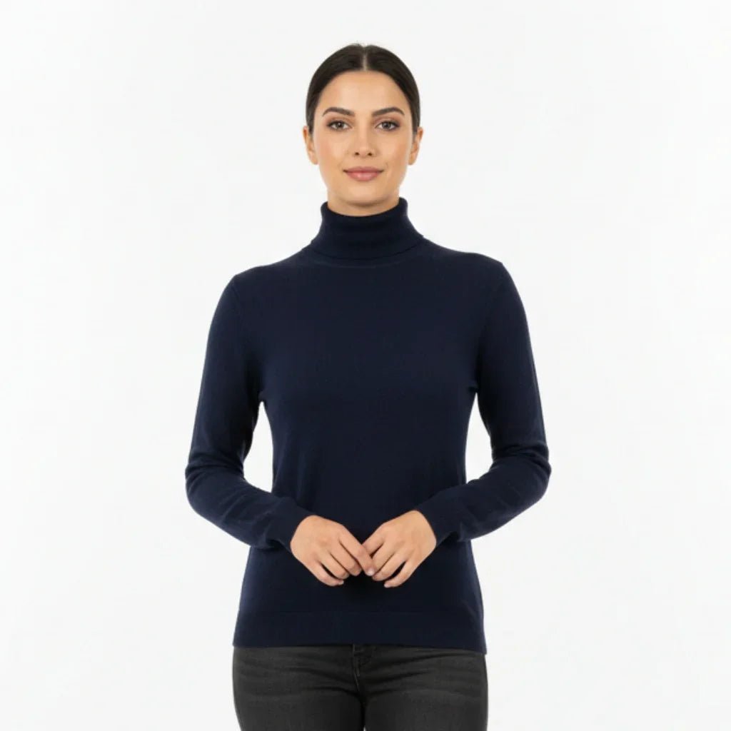 Femme portant un pull à col roulé bleu marine ajusté sur fond blanc
