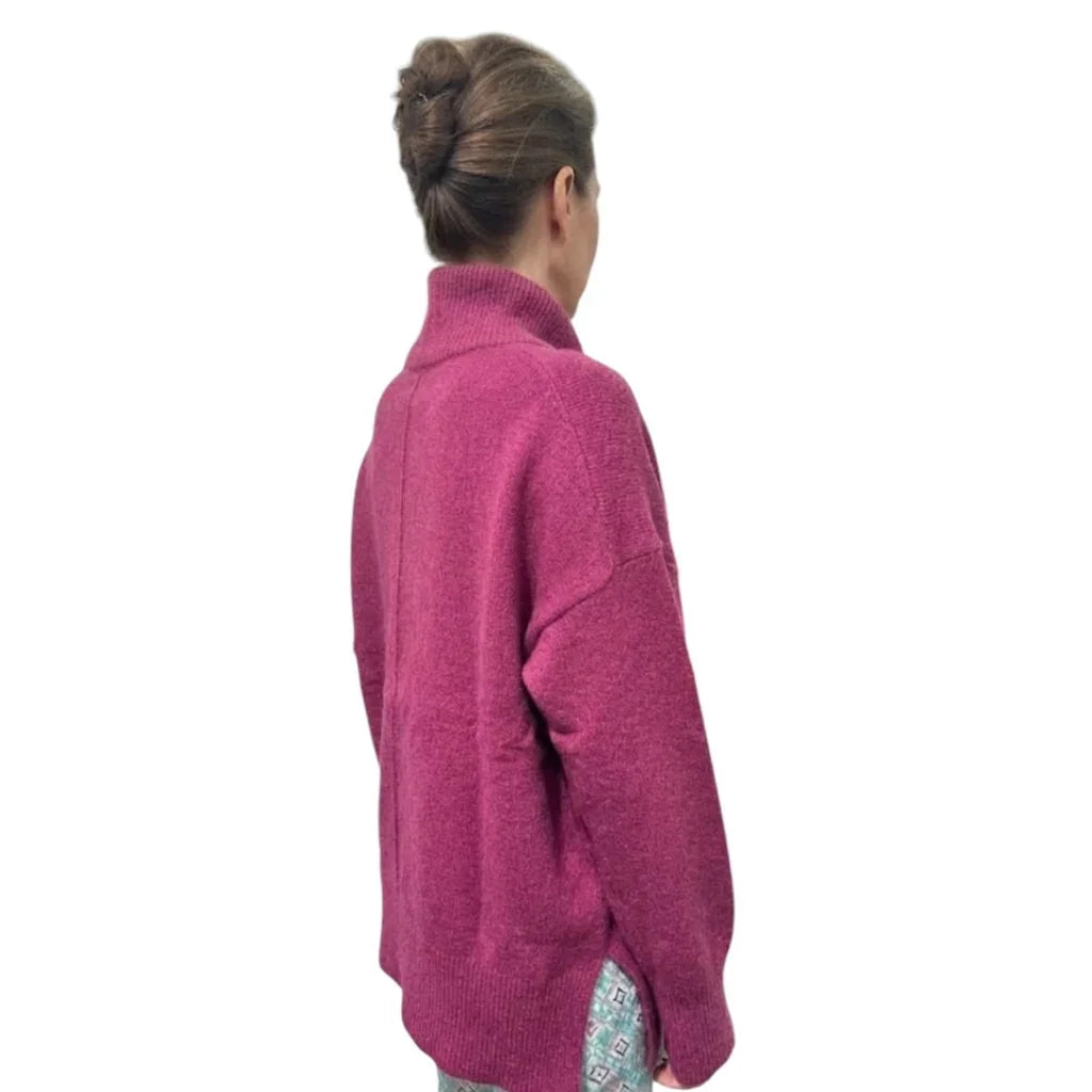Femme de dos portant un pull col roulé ample de couleur magenta de la marque C'est Elle