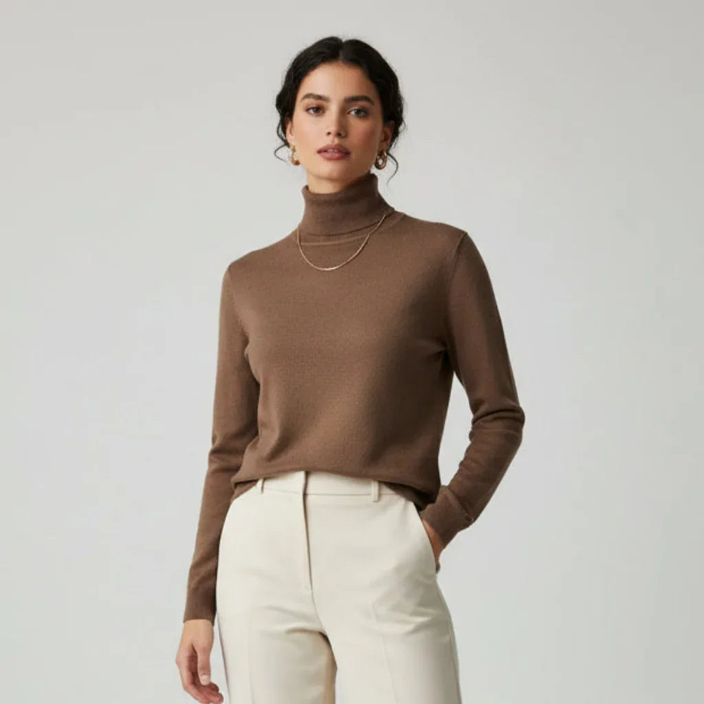 Femme portant un pull à col roulé marron et un pantalon blanc cassé.