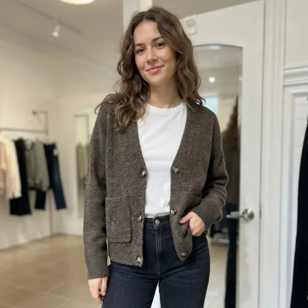 Femme portant un cardigan marron C'est Elle sur un t-shirt blanc et un jean noir.