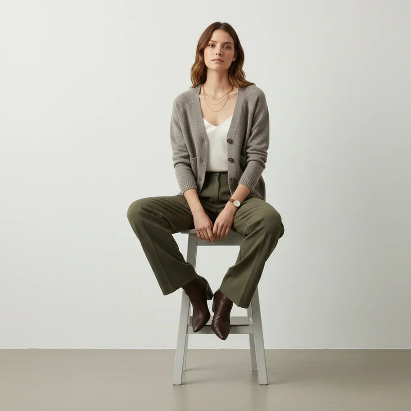 Femme portant un cardigan gris, un haut blanc et un pantalon vert olive C'est Elle.