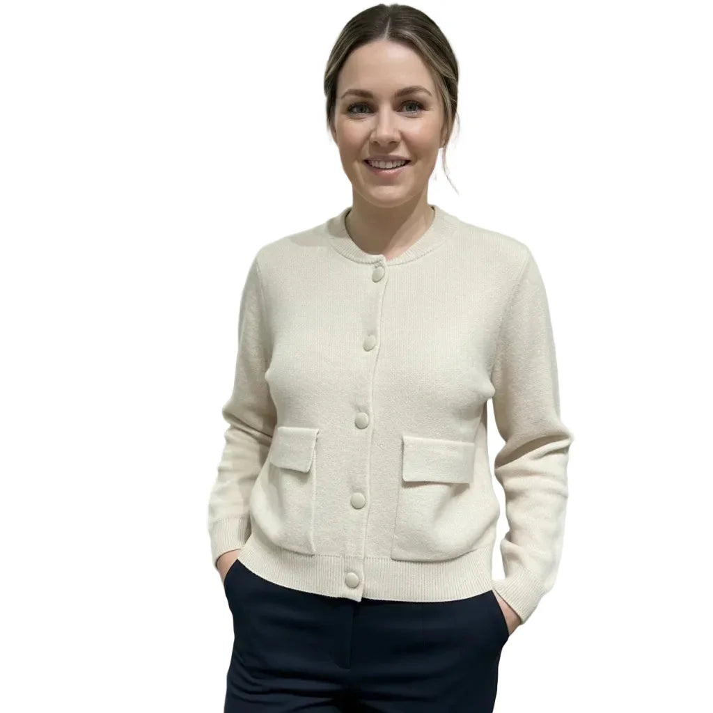 Femme portant un cardigan beige boutonné avec poches et pantalon bleu marine